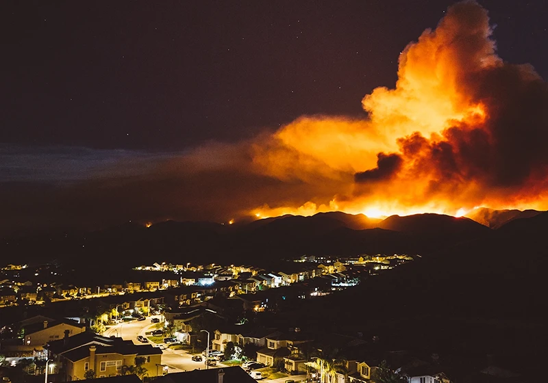 A suburban area with wildland fire on the horizon